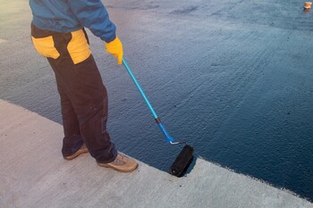 Roofer applying roof coating in Gulf Gate Estates, FL