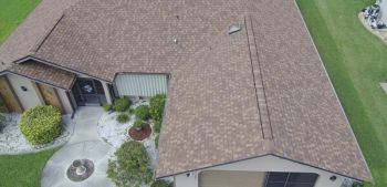 Roofer working on asphalt single roof.